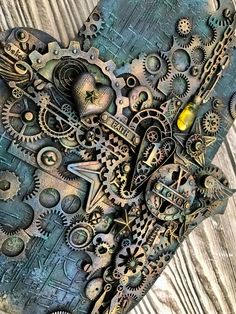 an intricate piece of art made out of metal gears and other mechanical parts on a wooden surface