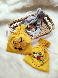 two small bags with embroidered flowers on them