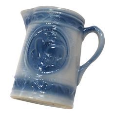 a blue and white ceramic mug with an ornate design