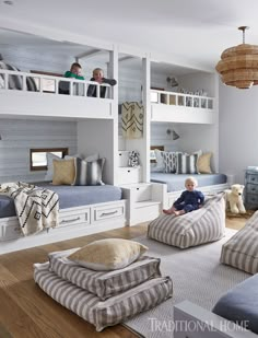 two children are sitting on bean bags in the middle of a room with bunk beds