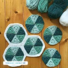 crocheted coasters and balls of yarn sitting on a wooden floor next to each other