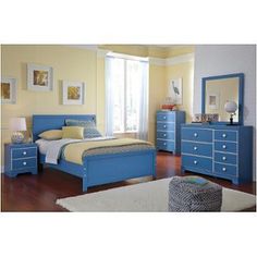 a bedroom with yellow walls, blue furniture and white rugs on the hardwood floor