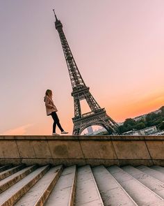 a woman walking up some steps towards the eiffel tower