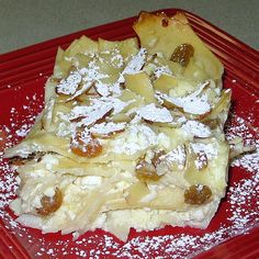 a red plate topped with pieces of pizza covered in powdered sugar and toppings