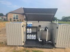 an outdoor storage shed with water tanks in the back