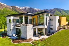 an aerial view of a modern home with mountains in the backgroung area