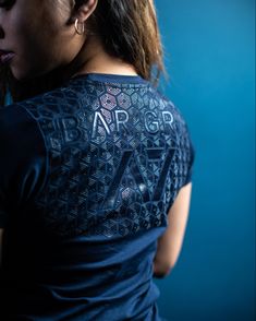 a woman with her back turned to the camera, wearing a t - shirt that reads arr gr