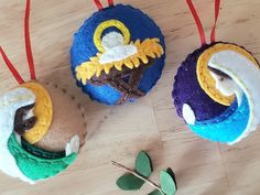 three ornaments are sitting on a wooden table