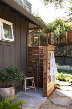 an outdoor shower with towels hanging from it's side and several pictures of the outside