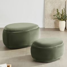 two green ottomans sitting on top of a white floor