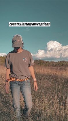 a man standing in the middle of a field wearing a hat and looking at something