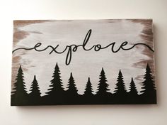 a wooden sign with the word explore written in black and white on top of pine trees