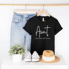 Looking for a fun and stylish way to show your love for your favorite aunt? Look no further than our "Aunt Like a Mom Only Cooler" t-shirt! Made from high-quality materials, this comfortable and durable tee is the perfect addition to any auntie's wardrobe. The design features the humorous phrase "Aunt Like a Mom Only Cooler" in trendy font, making it a great conversation starter and a unique way to show your appreciation for your aunt's important role in your life. This funny auntie tee makes a Aunt Birthday Gift, Cool Aunt, Aunt Birthday, Trendy Fonts, Auntie Shirts, New Aunt, Like A Mom, Aunt Gifts, Ladies T Shirt