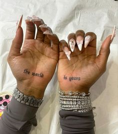 two hands with different designs on them, one has the words'the world is yours '