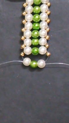 the beaded bracelet is made with green and white pearls