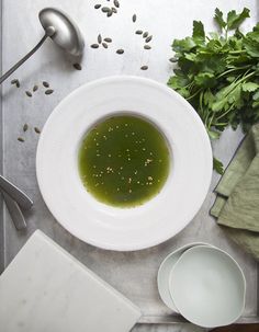 a white bowl filled with green liquid next to other ingredients