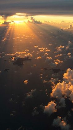 the sun shines brightly through clouds above the ocean in this aerial photo taken from an airplane