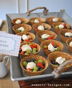 a tray filled with lots of different types of fruit in small baskets on top of a table