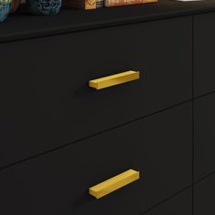 black dresser with gold handles and books on top