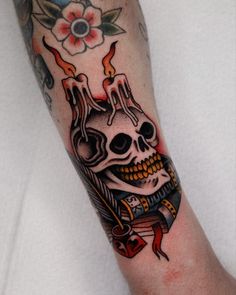 a person with a tattoo on their arm has a skull and flames coming out of it