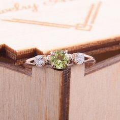 "Simple & dainty 14k rose gold peridot promise ring for her, Elegant 3 stone womens promise ring, Gold 3 stone peridot engagement ring WE OFFER UNLIMITED PERIOD INSTALLMENTS PLAN This is a beautiful, stunning, feminine ring that works well for all occasions, styles, and ages. You will love it! Ring information Main stone: Peridot Approximate size: 4.5mm Accent stone: Cubic zirconia Approximate size: 3mm Metal type: Gold Metal stamp: 14k solid gold Customization / Replacements It's easy to cr Adjustable Peridot Jewelry For Anniversary, Rose Gold Three-stone Promise Jewelry, Elegant Peridot Jewelry With Prong Setting, Green Three Stone Round Jewelry, Green Three-stone Round Jewelry, Peridot Jewelry With Center Stone In Round Cut, Promise Ring Jewelry With May Birthstone Center Stone, Three Stone Round Jewelry For May Birthstone, Peridot Jewelry With Round Cut Center Stone