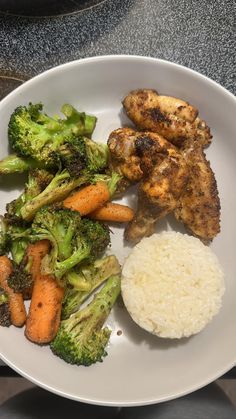 a white plate topped with chicken, broccoli and rice