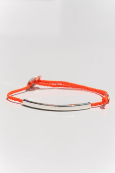 Adjustable 4mm bracelet, featuring a 2" sterling silver ID bar curved to hug your wrist. Each bracelet is lightly coated with wax for a 100% waterproof finish, so you can confidently wear your bracelet to shower, swim or surf. Designed for everyone, easily adjustable to fit most wrist sizes. Signature Bracelet, Neon Red, Brass Charms, Hug You