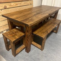 a wooden table and bench made out of wood planks with benches underneath it on carpeted flooring