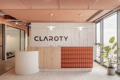 an empty office with large windows and a sign on the wall that says claroty