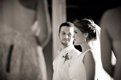 a man and woman standing next to each other in front of a mirror at a wedding