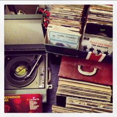 an old record player sitting on top of a pile of records