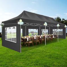 a large tent set up in the grass with tables and chairs under it for an outdoor event