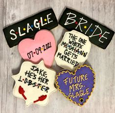 four decorated cookies with names on them sitting on top of a wooden table next to each other