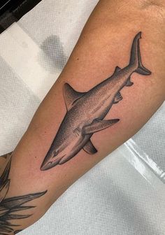 a man's arm with a shark tattoo on it