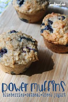 three blueberry muffins sitting on top of a wooden cutting board with the words power muffins written below it