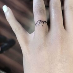 a hand with a small mountain tattoo on it