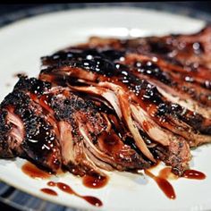 a piece of steak covered in bbq sauce on a plate