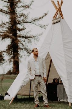 a man standing in front of a teepee