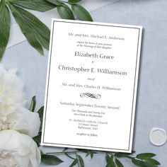 a wedding card with white flowers and greenery