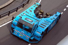 a large blue truck driving down a street next to a road divider on the side of a highway