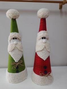 two santa claus hats are sitting on top of each other, one is green and the other is red