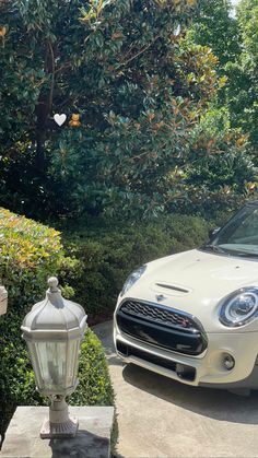 a small white car parked next to a lamp post