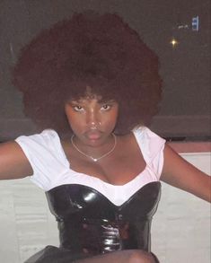 a woman with an afro is posing for the camera