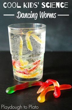 a glass filled with water and gummy worms