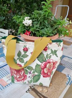 a purse sitting on top of a table next to a potted plant