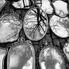 several mirrors reflecting trees and clouds in them