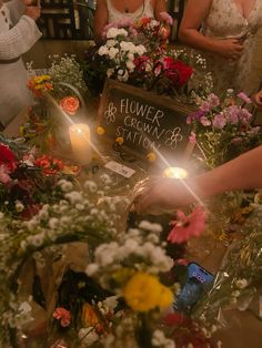 people standing around a table with flowers and candles