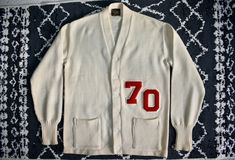 An amazing 1960's vintage Bush-Callahan Sporting Goods cream wool '70' college varsity letterman sweater cardigan. Bush-Callahan was a concession store in the Levi Strauss building in Indianapolis. It is in great condition for its age with no damage and just a few faint stains. It has all original buttons. Please see all images to get a complete idea of the condition. The size tag reads 42. Please check the measurements carefully to ensure the right fit. Measurements in inches (not doubled) - Pi Vintage White V-neck Outerwear, Retro White Sweater With Buttons, White Retro Sweater With Buttons, White Fitted Retro Cardigan, Vintage White V-neck Cardigan, Vintage Cotton V-neck Outerwear, Vintage White Cardigan With Buttons, Vintage White Sweater For Fall, Vintage Beige Cotton Sweater