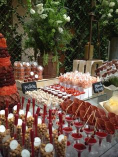 a table filled with lots of different types of desserts and candies on sticks