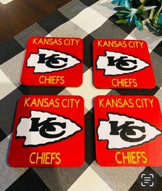 four kansas chiefs coasters sitting on top of a table